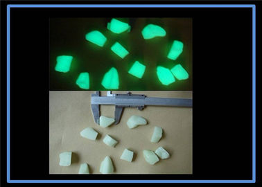 Fulgor amarelo dos materiais luminescentes de cor verde nas pedras escuras do jardim