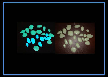 Pedra luminescente /Glow do godo do esmalte no seixo escuro